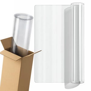 Puede incluir: Rollo y lámina de plástico transparente. El rollo está dentro de una caja de cartón, y la lámina se muestra al lado. El plástico es transparente, lo que permite ver el fondo. La caja es de color marrón claro.