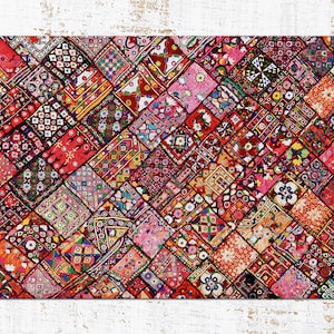 Op de afbeelding: Een kleurrijk patchwork-deken met verschillende geometrische patronen en ontwerpen in tinten rood, roze, blauw, groen en geel.