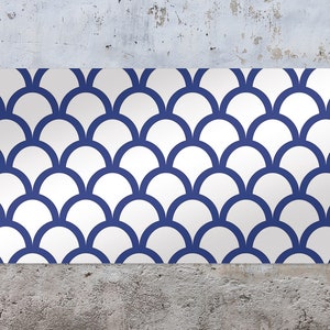 May include: A white and blue geometric pattern with a repeating design of overlapping half circles. The pattern is reminiscent of fish scales.