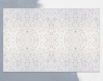 May include: A close-up of a white textured surface with a subtle pattern of small brown dots. The surface is slightly uneven and has a rough texture.