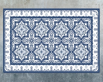 May include: A white and blue patterned rug with a geometric design. The rug has a border with a floral pattern.