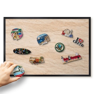 Op de afbeelding: Een rechthoekig magneetbord met een getextureerd beige oppervlak waarop diverse souvenir-magneten zijn bevestigd, waaronder ontwerpen met teksten zoals Mexico, Zadar, I Love Crete en Alanya, en een ronde magneet linksonder.
