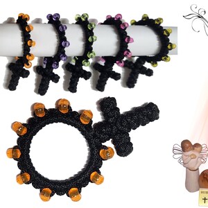 May include: Black crocheted bracelets with orange beads and a cross charm. The bracelets are displayed on a white surface. Spiritual Gifts by Orit is written in the upper right corner of the image.