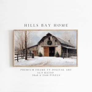 Puede incluir: Una impresión artística digital enmarcada de un granero cubierto de nieve con una puerta abierta y una corona. La obra de arte presenta un paisaje invernal con una valla y árboles. El texto "HILLS BAY HOME" está en la parte superior.