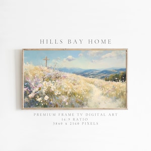 Puede incluir: Una impresión artística digital enmarcada que presenta un paisaje con una cruz en una colina, flores silvestres y colinas onduladas bajo un cielo azul. La obra de arte está etiquetada como "HILLS BAY HOME" y está diseñada para un televisor con marco premium con una relación de aspecto de 16:9 y 3840 x 2160 píxeles.