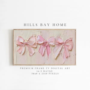Könnte beinhalten: Gerahmter digitaler Kunstdruck mit drei strukturierten rosa Schleifen auf cremefarbenem Hintergrund. Das Kunstwerk trägt die Bezeichnung "HILLS BAY HOME" und gibt ein 16:9-Verhältnis mit 3840 x 2160 Pixeln an, geeignet für einen Premium-Rahmen-TV.