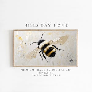 May include: A painting of a bumblebee in flight, with a light beige background and yellow accents. The bee is painted in a realistic style with black and yellow stripes. The painting is framed in a light wood frame.