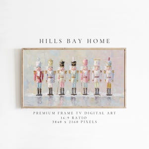May include: A framed digital art print featuring a row of seven colorful nutcracker soldiers. The artwork has a soft, painterly style with pastel colors and the text "HILLS BAY HOME" at the top. The print is labeled "PREMIUM FRAME TV DIGITAL ART".