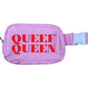 May include: A light pink fanny pack with the words "QUEEF QUEEN" in red block letters. The pack has a zipper closure and a pink adjustable strap with a white plastic buckle.