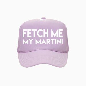 Puede incluir: Gorra de camionero lila claro con el texto blanco "FETCH ME MY MARTINI". La gorra tiene una visera curva y una parte trasera de malla.