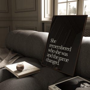 May include: A black and white framed print with the text "She remembered who she was and the game changed."