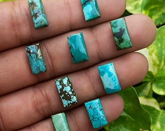 May include: A collection of eight rectangular turquoise gemstones, each featuring unique natural matrix patterns in shades of blue, green, and brown. The stones are polished with a smooth surface and display varied color intensity and veining.