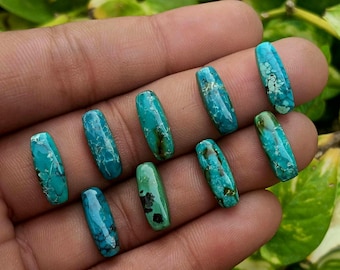 May include: A collection of nine elongated, rectangular turquoise gemstones featuring vibrant blue and green hues with intricate dark matrix veining patterns. Each polished stone displays a smooth, glossy surface with unique natural color variations.