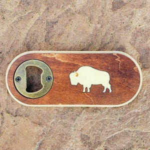 Wooden Buffalo Bottle Opener. Hand crafted and laser engraved. Magnet on back. 2.5&quot; x 5.5&quot; and 1/2&quot; thick.