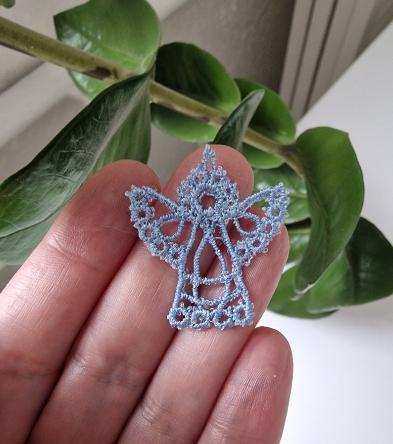 May include: A delicate blue lace angel ornament, perfect for adding a touch of elegance to your holiday decor.