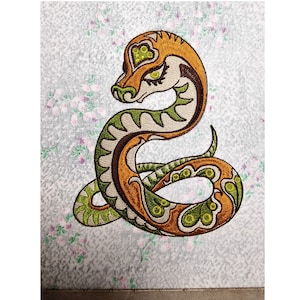 Peut inclure: Broderie représentant un serpent vert et orange aux détails complexes. Le serpent est enroulé en forme de spirale, la tête tournée vers le spectateur.