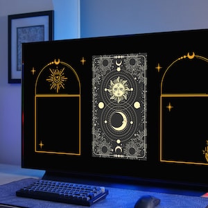 May include: A computer monitor displaying a black background with three gold frames. Each frame contains a celestial design with a sun, moon, and stars. The center frame features a more detailed design with a sun and moon face.