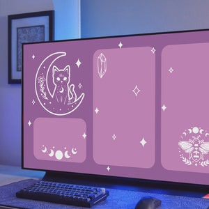 May include: A purple computer monitor with a digital wallpaper featuring a white cat sitting on a crescent moon, a crystal, a bee with a moon and stars around it, and a moon phase design. The wallpaper has a starry night theme.