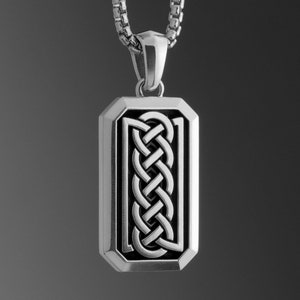 Puede incluir: Collar de cadena de plata con un colgante rectangular con un diseño de nudo celta negro.