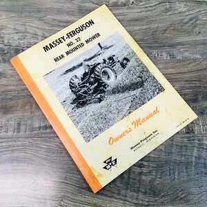 May include: A black and white photo of a tractor with a rear-mounted mower. The tractor is in a field and the mower is cutting grass. The image is from an owner's manual for a Massey-Ferguson No. 32 rear-mounted mower.