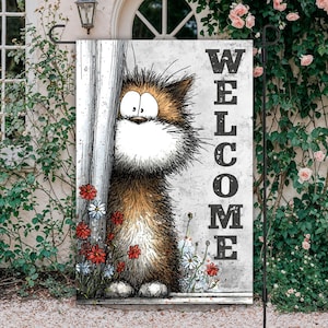 Puede incluir: Una bandera de jardín con una ilustración de un gato de dibujos animados mirando desde detrás de un poste. El gato es marrón y blanco con ojos grandes. La palabra "WELCOME" está impresa verticalmente en negro sobre un fondo gris. Flores rojas y blancas en la base.