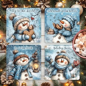 Peut inclure: Ensemble de quatre dessous de verre carrés de Noël avec des illustrations de bonhommes de neige. Chaque dessous de verre présente un design différent avec des phrases comme "Joy to the World" et "Holiday Cheer". Les bonhommes de neige portent des chapeaux et des écharpes bleus.