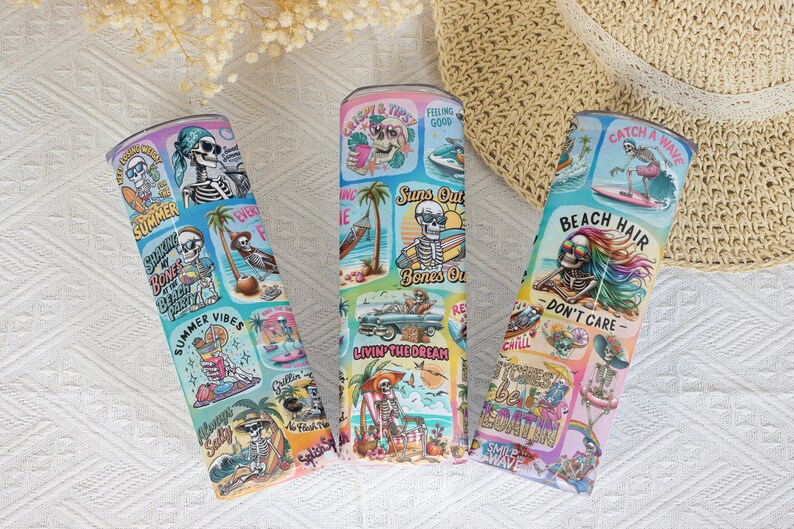 May include: Three colorful stainless steel tumblers with a summer beach theme. Each tumbler features a skeleton graphic with different summer-themed phrases like "Suns Out Bones Out" and "Beach Hair Don't Care".