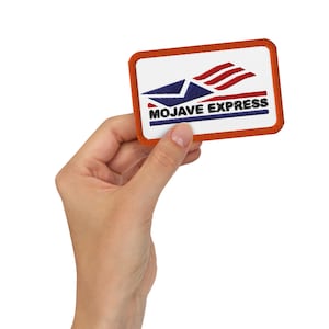 May include: A rectangular patch with an orange border and a white center. The patch features a stylized design of a blue envelope with red and white stripes above it, and the words "MOJAVE EXPRESS" in blue and black.