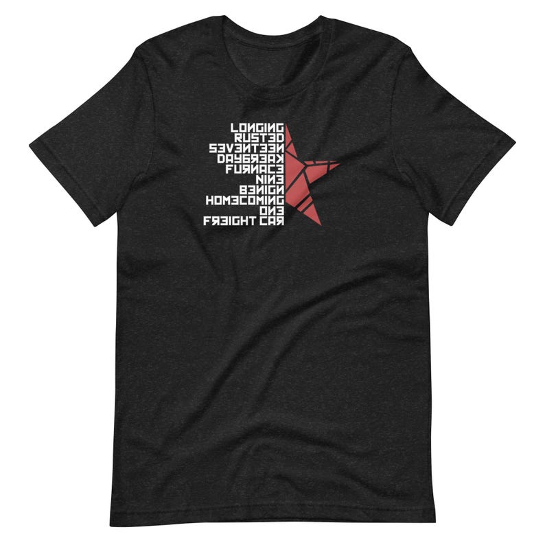 May include: Dark gray t-shirt featuring a red star design with white text. The text includes words like "Longing", "Rusted", and "Freight Car". The shirt is a short-sleeved crew neck.