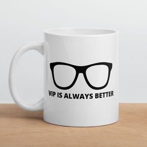 May include: White ceramic coffee mug with a black pair of eyeglasses and the text "VIP is always better".