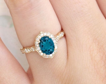 May include: A gold ring with a teal oval gemstone surrounded by a halo of smaller diamonds.