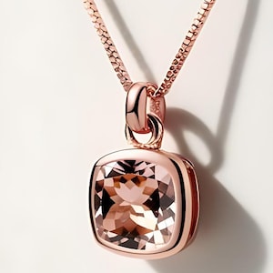 May include: A rose gold necklace with a square-shaped pendant featuring a light pink gemstone.