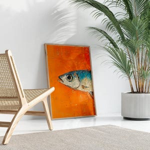 May include: A framed painting of a blue and silver fish on an orange background. The fish is facing right and has a large eye. The painting is in a wooden frame.