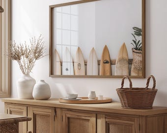 May include: A framed print of a row of surfboards hanging on a wall above a wooden cabinet with a wicker basket and ceramic vases. The surfboards are all different colors and have different designs.