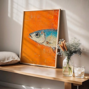 May include: A framed painting of a blue and white fish on an orange background. The fish is facing to the right and has a large eye. The painting is in a wooden frame.