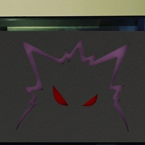 May include: A black and purple Nintendo Switch console skin with a red-eyed monster graphic. The skin is designed to fit the Nintendo Switch console.