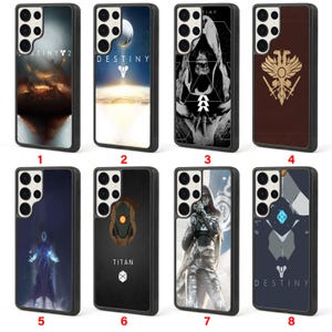 May include: A collection of eight black phone cases with various designs. The cases feature graphics and text, including the word "DESTINY" and the number "2". The designs include a moon, a figure, and a symbol.