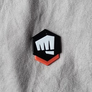 K&ouml;nnte beinhalten: Ein schwarzes und wei&szlig;es Faustsymbol mit rotem Umriss. Die Faust ist in die Luft erhoben und symbolisiert St&auml;rke und Macht.