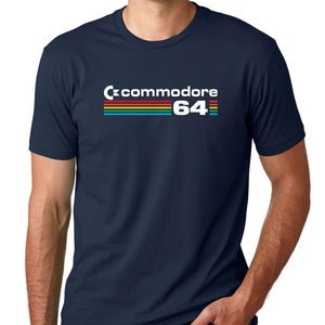 May include: A navy blue t-shirt with a white graphic of a rainbow and the text "Commodore 64".