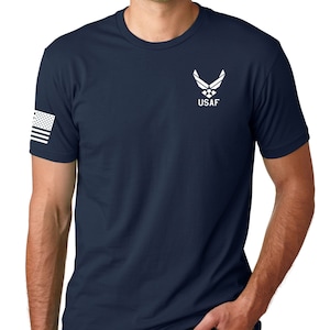 May include: A navy blue t-shirt with a white US Air Force logo and the text "USAF" on the front. The left sleeve has a small American flag.