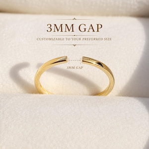 May include: A gold-colored open band ring featuring a 3MM GAP, with text above stating 3MM GAP and CUSTOMIZABLE TO YOUR PREFERRED SIZE. The ring has a smooth, polished finish and a circular shape with a small opening at the top center.