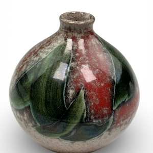 May include: A ceramic vase with a rounded body and a narrow neck. The vase features a speckled, light beige base with a design of green and red leaf-like patterns. The rim of the vase is a darker brown color.