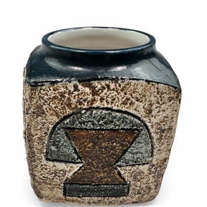 May include: A textured ceramic vase with a dark blue rim and a geometric design in shades of brown, gray, and black. The vase has a square shape with rounded edges and a cream-colored interior.