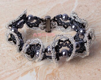 May include: A black and silver beaded bracelet with a silver clasp and gray pearls.