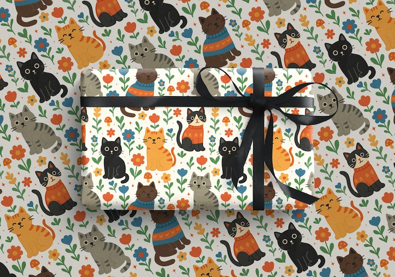 May include: Gift wrap featuring a repeating pattern of cartoon cats in various colors, including orange, black, and gray, interspersed with flowers and mushrooms on a white background. A black ribbon is tied around the wrapped gift.
