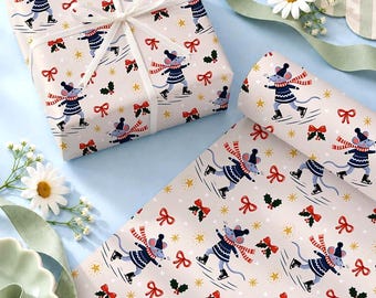 May include: Wrapping paper featuring a repeating pattern of blue mice wearing dark blue sweaters, hats, and red-and-white striped scarves while ice skating, interspersed with red bows, green holly leaves, and yellow stars on a light background.
