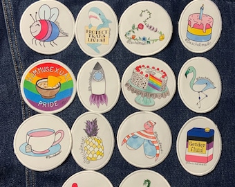 Queer Feminist Pun patches pride flags, shark plushy, puns, clitoris
