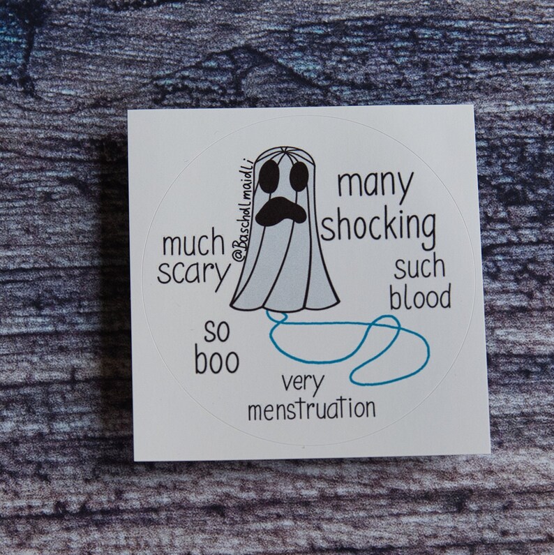 May include: A white, circular sticker featuring a cartoon ghost with a sad expression. Text around the ghost reads "much scary," "so boo," "many shocking," "such blood," and "very menstruation."