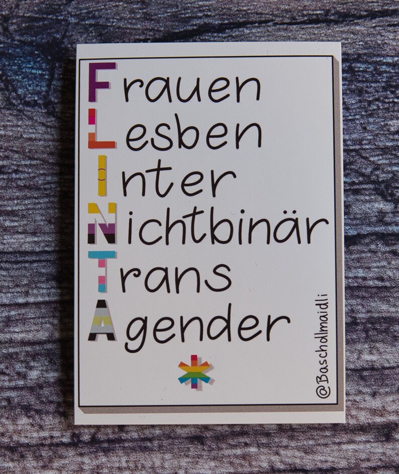 May include: White card with the acronym "FLINT" written vertically in black. Each letter is decorated with a different pride flag. The word "Frauen" is written next to the "F", "Lesben" next to the "L", "Inter" next to the "I", "Nichtbin&auml;r" next to the "N", "Trans" next to the "T", and "Gender" next to the "A". A rainbow asterisk is at the bottom of the card. The text "@Bascholdmaidli" is written in the bottom right corner.