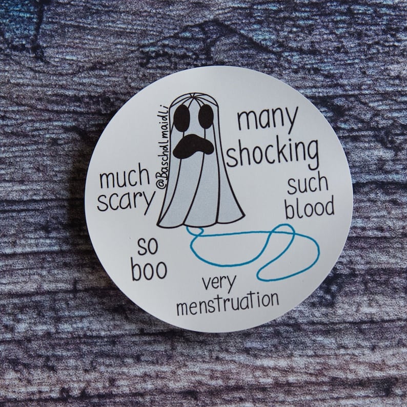May include: A round white sticker featuring a cartoon ghost with a sad expression. The ghost is light blue with black eyes and a black mouth. Text includes "much scary", "many shocking", "so boo", "such blood", and "very menstruation".